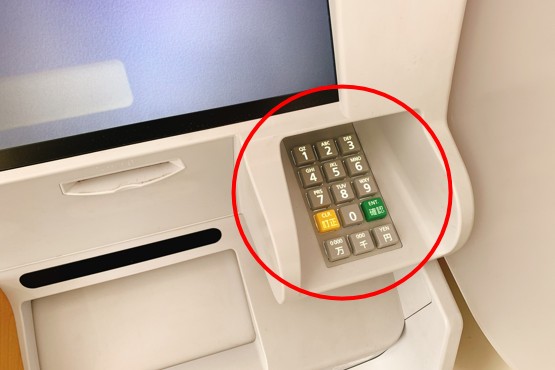 ATMの数字キーを使って企業コードを入力する